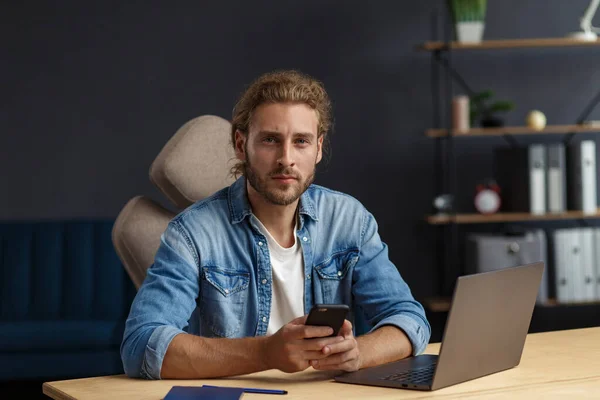 Retrato de homem encaracolado bonito sorridente de cabelos compridos usando laptop para uma reunião on-line em videochamada. A trabalhar em casa. Comunicação online com colegas e freelancers e videoconferência — Fotografia de Stock