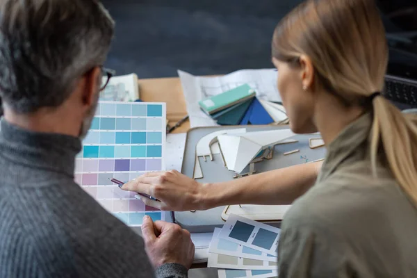 Interieur ontwerpers team werken in het kantoor met kleurenpalet. Architecten selecteren kleuren voor het bouwen met behulp van kleurstalen, schetsen en planning bouwproject. Partners discussiëren op het werk — Stockfoto