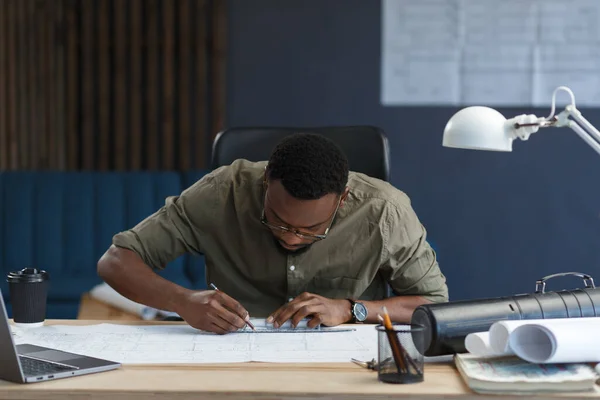 Architecte afro-américain travaillant au bureau avec des plans. Ingénieur inspecter le plan architectural, esquisser un projet de construction. Portrait d'un bel homme noir assis sur le lieu de travail. Concept d'entreprise — Photo