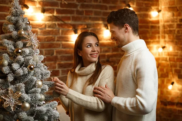 Красивая молодая пара дома украшает елку. Проводить время вместе, отношения и концепция людей. Зимние праздники, рождественские праздники, новогодняя концепция — стоковое фото