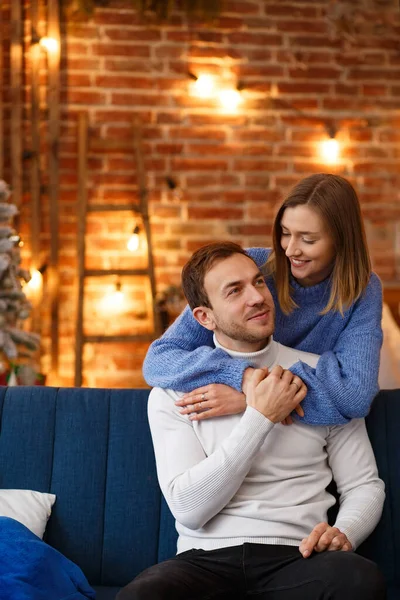 Портрет красивой улыбающейся пары, обнимающейся в канун Рождества. Прекрасная молодая пара дома наслаждается проведением времени вместе. Зимние праздники, рождественские праздники, новогодняя концепция — стоковое фото