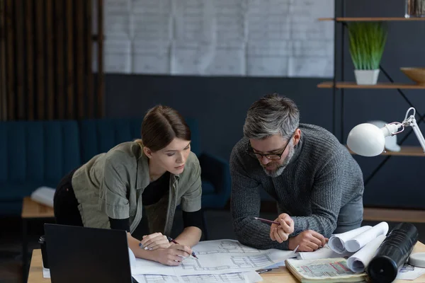 Equipo de ingenieros trabajando en la oficina con planos y equipos de arquitectos, bocetos, negociación y planificación de proyectos de construcción. Socios discutiendo en el trabajo. Concepto de construcción empresarial — Foto de Stock