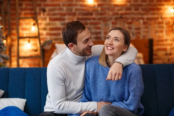 Retrato de una hermosa pareja sonriente abrazándose en la víspera de Navidad. Hermosa pareja joven en casa disfrutando pasar tiempo juntos. Vacaciones de invierno, celebraciones de Navidad, concepto de Año Nuevo — Foto de Stock