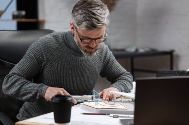 3D mimar, 3D model bir binada çalışıyor. Mühendis bina planını inceliyor, inşaat projesi için yeni fikirler arıyor. İş yerindeki yakışıklı sakallı adam. İş inşa kavramı