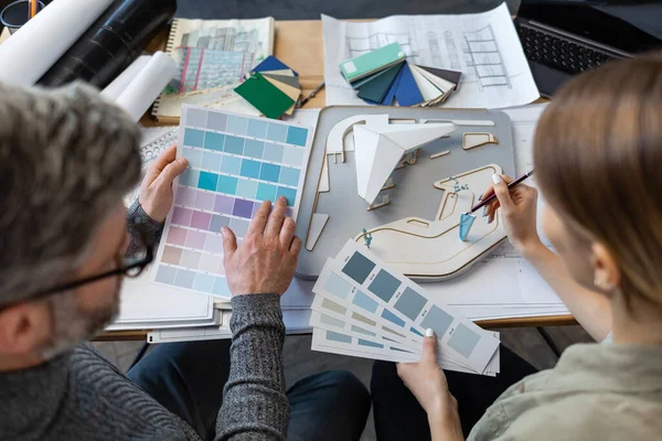 Equipo de interioristas trabajando en oficina con paleta de colores. Los arquitectos seleccionan colores para la construcción utilizando muestras de color, bocetos y proyectos de construcción de planificación. Socios discutiendo en el trabajo — Foto de Stock