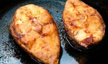 İki biftek kızarmış paslanmaz çelik tava üzerinde Ghee içinde olmak balık