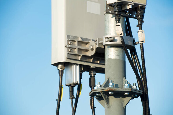 Telecommunication tower with sector antennas against the blue sky