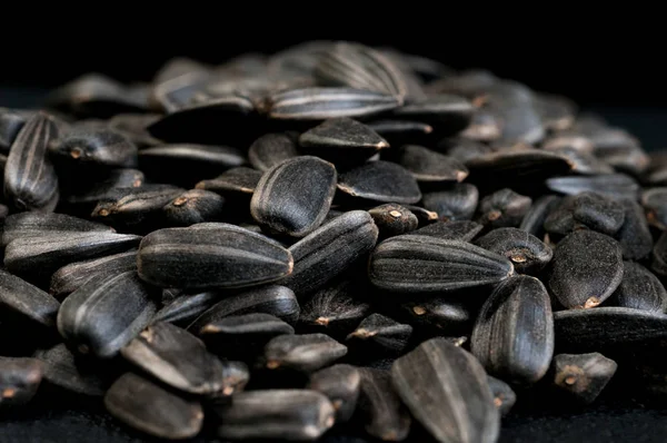 Sunflower seeds. Seed texture . Black and white roasted organic seeds with dark background. Food photography in studio.