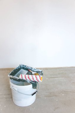 Çimento duvara uygulanan astar. Boş kova, fırça ve silindir işten sonra yaptı. Bina kavramı