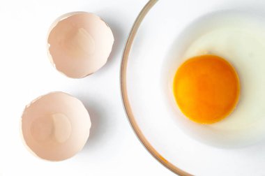 Cam ve beyaz bir arka plan üzerinde izole kabuk içinde çiğ yumurta