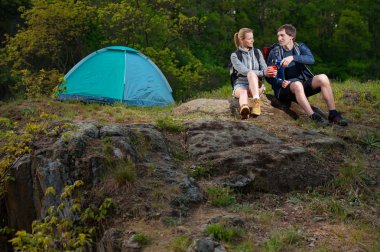 İki yürüyüşçü sırt çantaları ve sabah erken, sıcak çay. Seyahat, tatil, tatil ve macera kavramı.
