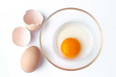 yumurta ve bir kase beyaz zemin üzerine açık yumurta kabuğu. Üstten görünüm portre