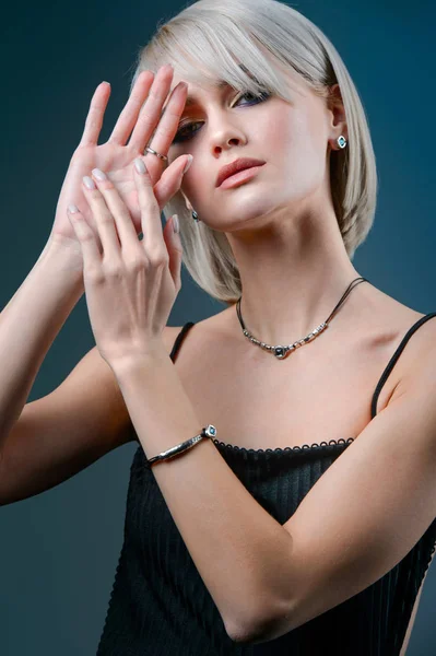 Fashion model woman wearing necklace with blue stone.