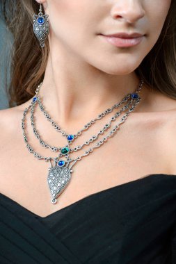 Onu takı aksesuar ve koyu arka plan üzerinde izole takı giyim moda kavramı içinde kapalı gösteren kadın