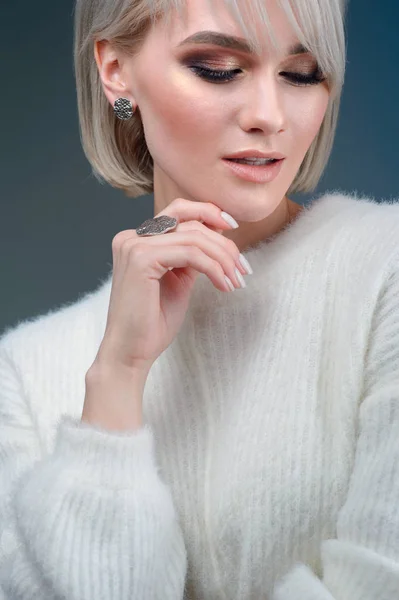 De blonde met een mooie ring en oorbellen poseren in de stoeterij — Stockfoto