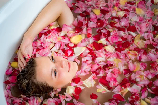 Meisje in de badkamer met rozenblaadjes, close-up portret — Stockfoto