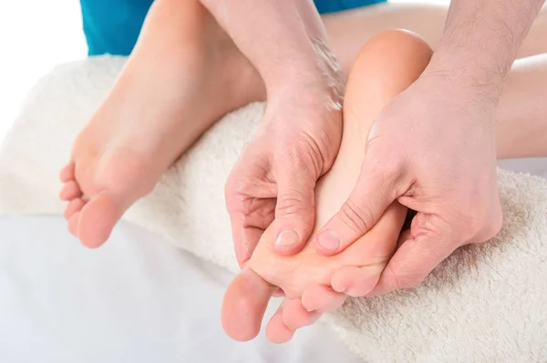 Man hands giving massage to soft bare feet