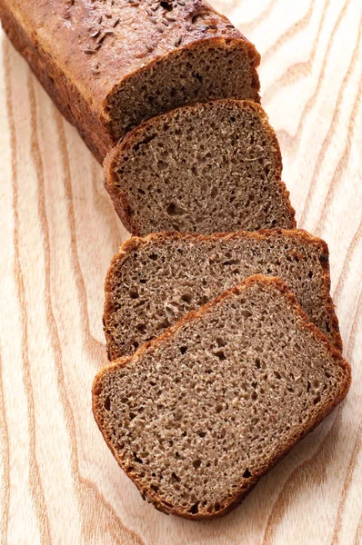 Bochník chleba a žitný chléb na dřevěné pozadí — Stock fotografie