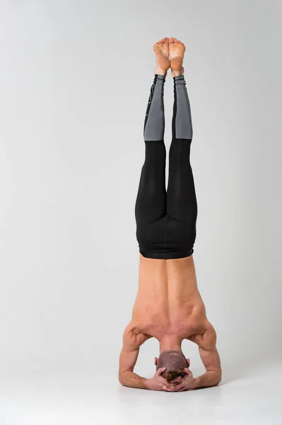 Strong man doing yoga handstand — Stock Photo, Image