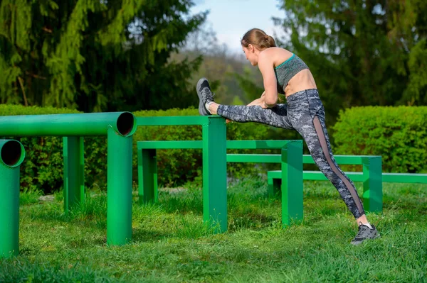 Fitness Frau Beine strecken, vor dem Lauftraining Aufwärmübungen machen — Stockfoto