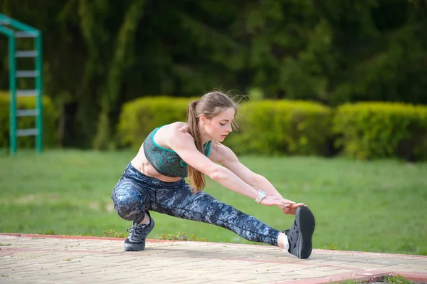 Menina atlética realiza exercícios de alongamento e isquiotibiais — Fotografia de Stock