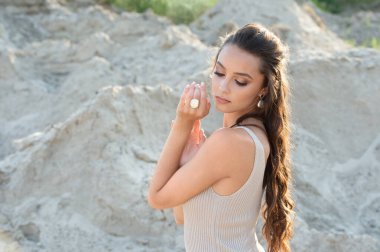 Gün batımında elbise ve mücevher içinde poz veren güzel bir manken. Açık hava modası