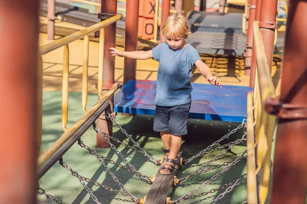 Engraçado bonito bebê feliz jogando no playground. A emoção da felicidade, diversão, alegria — Fotografia de Stock