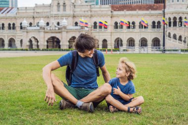 Baba ve oğul Merdeka Meydanı ve Sultan Abdul Samad Binası arka plan üzerinde. Çocuk kavramı ile seyahat.