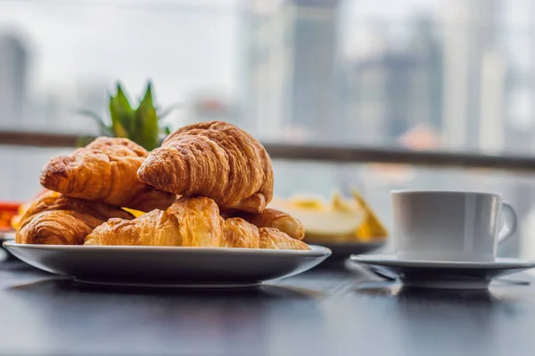 Frühstückstisch mit Kaffeeobst und Brotcroisant auf einem Balkon vor dem Hintergrund der Großstadt — Stockfoto