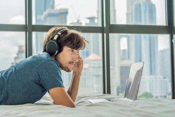 Jongeman Bezig Met Een Laptop Zijn Bed Een Achtergrond Van — Stockfoto