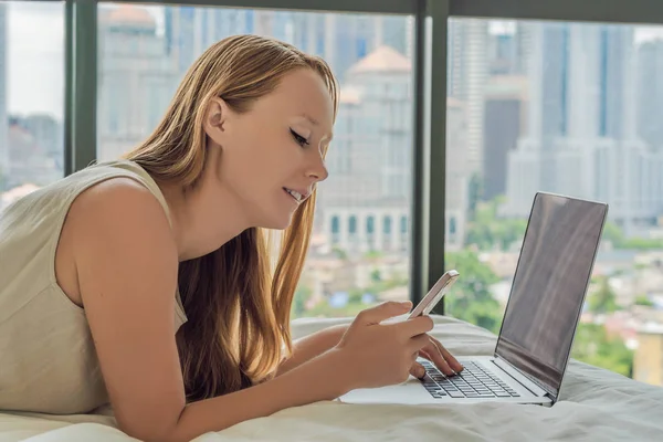 年轻女子正在阳台上的笔记本电脑上俯瞰摩天大楼 自由职业者 远程工作 在家工作 — 图库照片