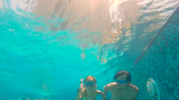 Slowmotion submarino disparo de padre y su hijo pequeño swining buceo y divertirse en una piscina — Vídeo de stock