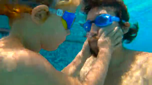 Slowmotion plan sous-marin de père et son fils tout-petit nageant plongée et s'amusant dans une piscine — Video