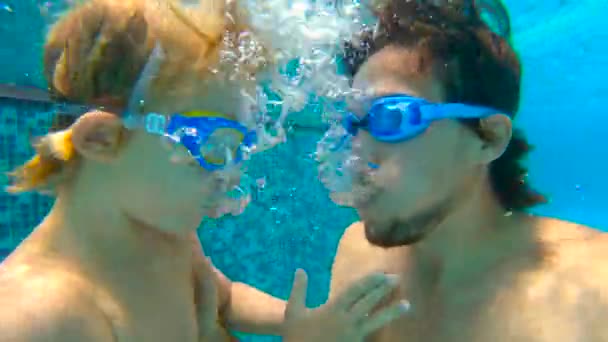 Slowmotion submarino disparo de padre y su hijo pequeño swining buceo y divertirse en una piscina — Vídeos de Stock