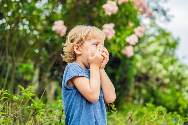 Jongetje Niezen Het Park Tegen Achtergrond Van Een Bloeiende Boom — Stockfoto