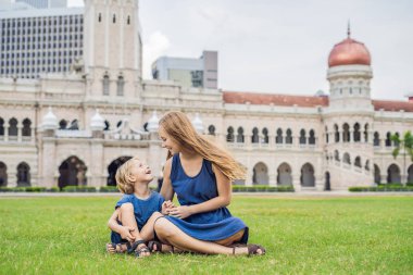 Anne ve oğlu Merdeka Meydanı ve Sultan Abdul Samad Binası arka plan üzerinde. Çocuk kavramı ile seyahat.