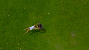 Bir baba oğlu yeşil çim üzerinde onun kollarında çember hava slowmotion vurdu. Kamera yükseltir kadar