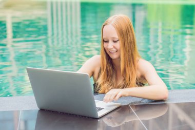 Onun smartphone içinde tarama otelde onu laptop ile havuzun oturan genç kadın serbest meslek sahibi. Bayramlarda meşgul. Uzak iş kavramı. Metniniz için kopya alanı.