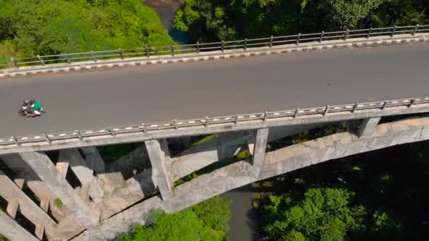 Foto aérea de un puente alto que cruza un cañón con un río en su fondo en los trópicos — Vídeos de Stock