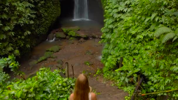 Aerial shot of a young woman visiting the Leke Leke waterfall in jungles of Bali, Indonesia — Stock Video