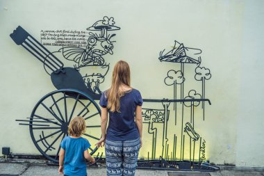 Penang, Malezya - 20 Nisan 2018: Anne ve oğlu arka planda eski evler eski şehir Georgetown'da, Penang, Malezya.