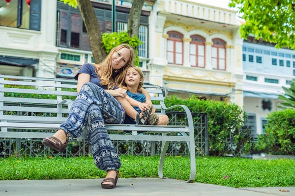 Mom and son in the background of Old houses in the Old Town of Georgetown, Penang, Malaysia.