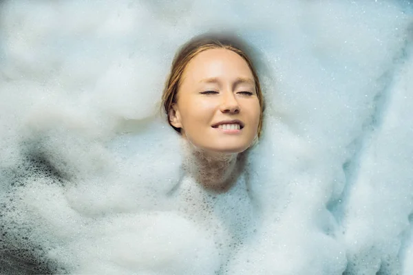 放松的年轻女子躺在泡沫浴 — 图库照片