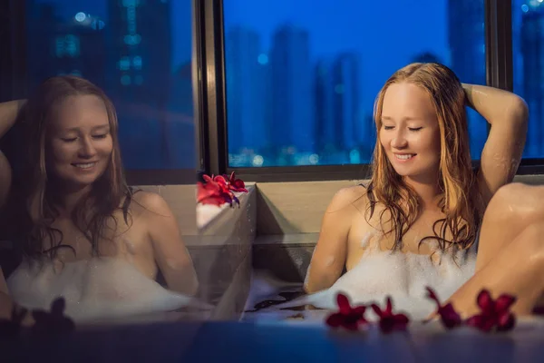 Young Woman Sits Bath Foam Frangipani Flowers Background Panoramic Window — Stock Photo, Image