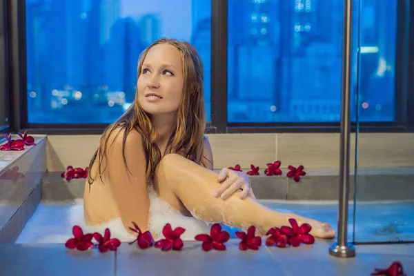 Młoda Kobieta Siedzi Kąpieli Pianką Frangipani Kwiaty Tle Panoramiczne Okna — Zdjęcie stockowe