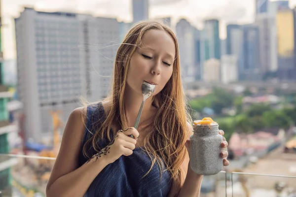 Young Woman Eating Chia Pudding Her Balcony Overlooking Big City — Stock Photo, Image