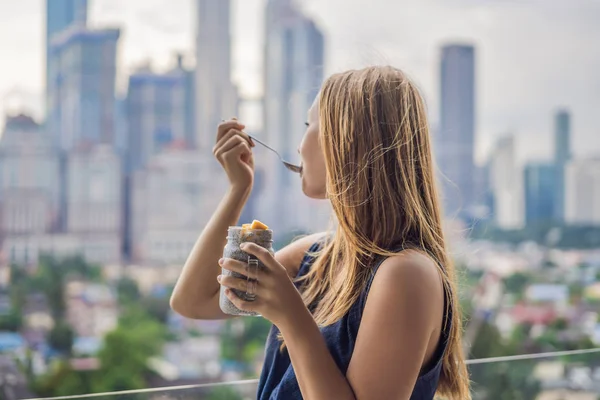 Молода Жінка Їсть Пудинг Чіа Балконі Видом Велике Місто — стокове фото