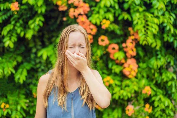 開花ツリーの背景に公園で若い女性のくしゃみ アレルギー花粉コンセプト — ストック写真