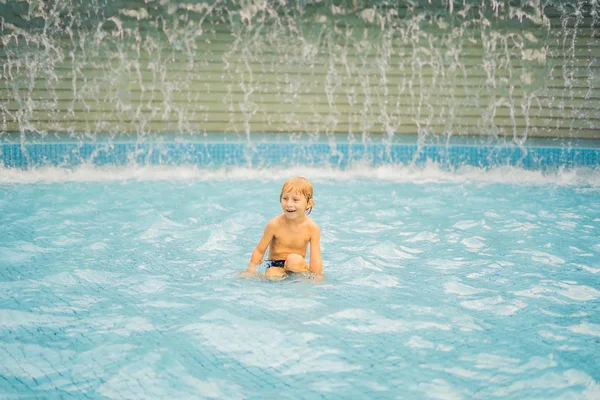 Küçük çocuk yüzme havuzunda eğleniyor.