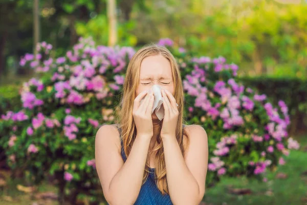 花粉アレルギーの概念 若い女性は くしゃみをする予定です 開花木を背景に — ストック写真